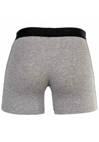 Grå bomullsshorts med svart elastisk midjeresår. Har en len tygkänsla och en åtsittande design. Inga synliga mönster eller detaljer.
