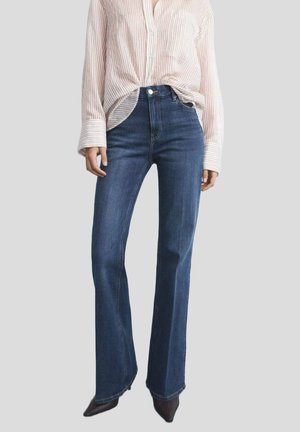 High-waisted flared jeans in dark blue denim, featuring a clean waistband, front pockets, and subtle stitching detail.
