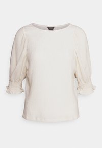 Top bianco a maniche corte con finitura testurizzata e dettagli arricciati sui polsini. Presenta un colletto rotondo e una vestibilità leggermente ampia.