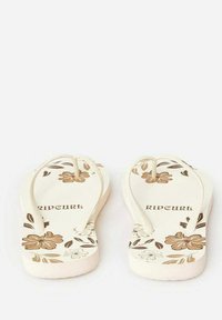 Des tongs avec une base crème, ornées de motifs floraux marron. Elles possèdent des semelles plates et des fines lanières ; marquées avec "RIPCURL."