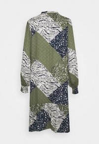 Långärmad klänning med ett lapptäckesdesign som har gröna, marinblå och vita färger. Mönstren inkluderar blommor, ränder och en rutad textur.