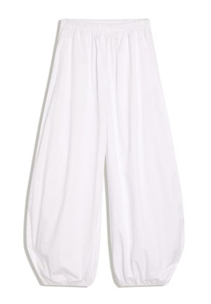 Løse hvide bomuldsbukser med elastisk talje og rynkede kanter, designet til en afslappet pasform.
