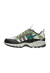 Sneaker Nike cu un interior din plasă în negru, alb și verde, cu o talpă texturată și un logo verde proeminent pe lateral.