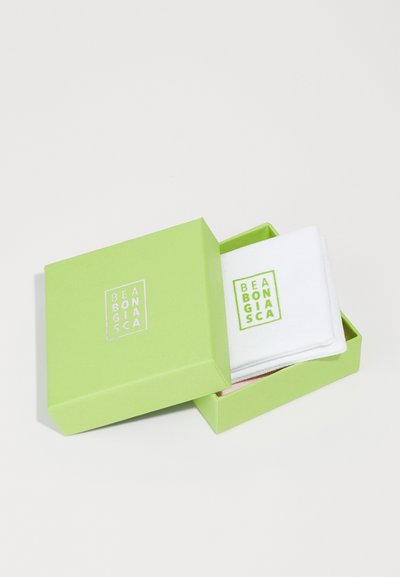Weiße Stoffgegenstände in einer hellgrünen Box mit einem in Weiß und leuchtendem Grün aufgedruckten Logo. Die Box hat einen Deckel und eine glatte Oberfläche.