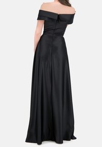 Svart avaxlat klänning i slät satin, med en figurnära livstycke och ett flödande kjol med en dold dragkedja på baksidan.