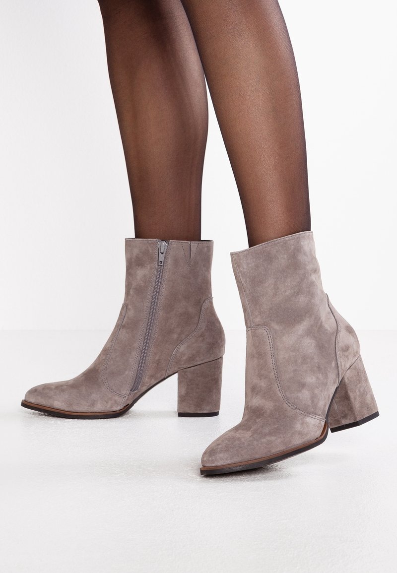 Szare zamszowe botki za kostkę z grubym obcasem, spiczastym noskiem i bocznym zamkiem błyskawicznym. Gładka tekstura i minimalistyczny design bez widocznych wzorów.