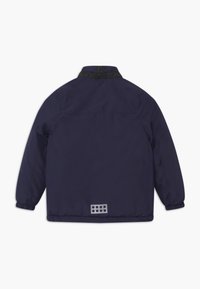 Navy blue lekka kurtka z kołnierzykiem na zatrzask, elastycznymi mankietami oraz odblaskowym prostokątnym akcentem na dolnej części pleców.