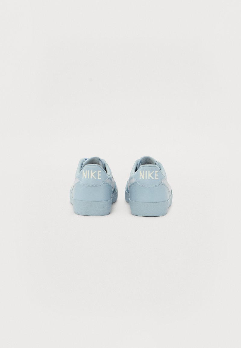 Baskets Nike bleu clair avec une texture lisse, une forme arrondie et un accent en logo blanc sur le talon. Semelle en caoutchouc conçue pour le confort.