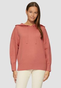 Różowa bluza z kapturem w miękkim materiale, o luźnym kroju, z ściągaczami na mankietach i u dołu. Z przodu z wiązaniami przy dekolcie.