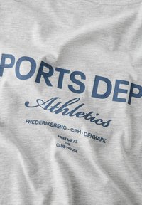 Grå bomulds t-shirt med marineblå tekst. Designet inkluderer "SPORTS DEP", "Atletik" og steddetaljer, med en blød, glat tekstur.