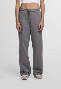 Gray, relaxed-fit sweatpants with an elastic waistband, front pockets, and a drawstring. Made of soft, textured fabric.
