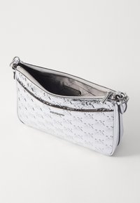 Sølv metallisk crossbody-veske med preget logo-mønster, glidelås og en enkelt justerbar stropp. Glatt tekstur med et elegant design.