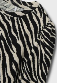 Melnā un baltā zebra svītru garām piedurknēm krekls ar ribotu tekstūru un apaļu kakla izgriezumu. Audums izskatās mīksts un nedaudz teksturēts.