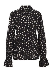 Melna blūze ar baltu punktu rakstu. Tai ir apkaklējams kakla izgriezums un volānu aproces garajās piedurknēs.