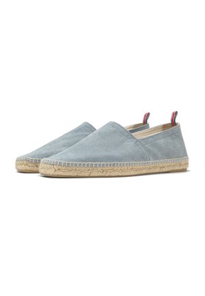 Lichtblauwe espadrilles met instapmodel, gemaakt van stof, met geweven juten zolen en trekbandjes in rood, wit en blauw bij de hiel.