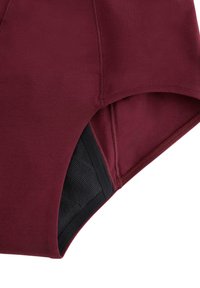 Shorts in tessuto elasticizzato color borgogna con fodera interna nera, caratterizzati da una texture liscia e cuciture piatte per il massimo comfort, tagliati per una vestibilità aderente.