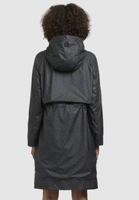 Donkergrijze, gestippelde regenjas met een capuchon, een getailleerde taille, lange mouwen en een lichte glans. Heeft een logo-detail op de achterkant.