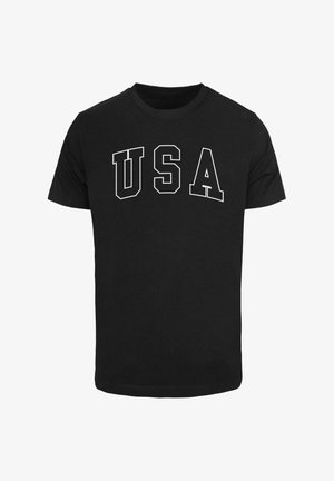 Černé bavlněné tričko s výraznými bílými písmeny, která na hrudi tvoří nápis "USA". Klasický kulatý výstřih, krátké rukávy a standardní střih.