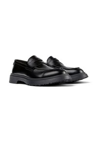 Mocasines de penny de cuero negro con suelas de goma gruesas y texturizadas, punteras redondeadas y superficie suave, exhibidos uno al lado del otro sobre fondo blanco.