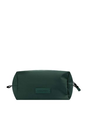 Neceser de tela verde con forma cilíndrica, que presenta un parche de logo de cuero y un tirador de cremallera negro. Textura suave, diseño minimalista.