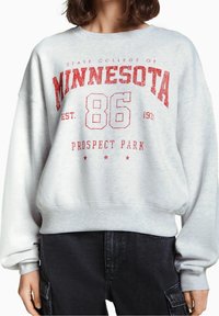 Harmaa collegepaita punaisella painetulla tekstillä: "MINNESOTA 86 PROSPECT PARK EST. 1931." Löysä istuvuus, resorit hihansuissa ja helmassa.