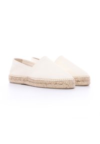 Espadrilles blanches en toile avec une semelle plate en jute tressé. Elles présentent un bout arrondi et un design à enfiler, avec des détails de couture minimalistes.