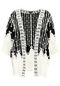 Kimono in pizzo bianco e nero con motivi intricati, caratterizzato da dettagli in perline e un design aperto e morbido. Tessuto testurizzato con elementi trasparenti.