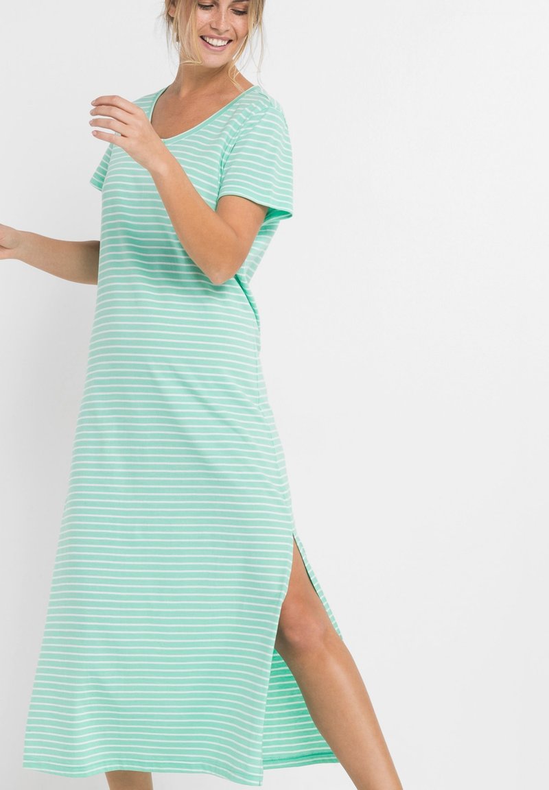 Abito rigato verde menta con scollo a V, maniche corte e spacchi laterali. Realizzato in un tessuto morbido con una vestibilità rilassata, presenta righe orizzontali bianche.