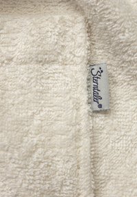 Asciugamano bianco e soffice con superficie testurizzata. Presenta un'etichetta logo cucita in grigio con testo blu. Tessuto morbido e assorbente.