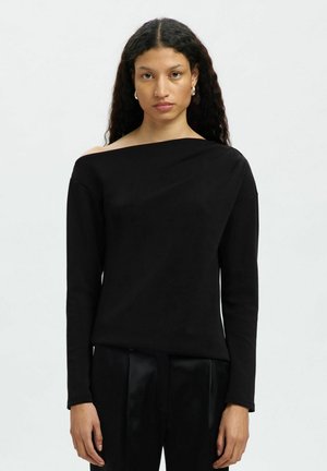 Črna dolga majica z dolgimi rokavi z asimetričnim izrezom. Narejena iz gladkega materiala, ki se prilega telesu in ima subtilno draperijo na rami.