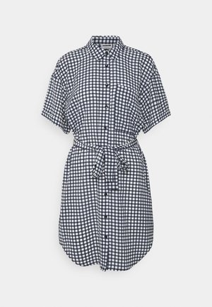 Short-sleeve navy and white checkered shirt dress with front buttons, chest pocket, collar, and tied waist belt.