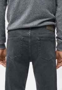 Jeans de mezclilla gris con una textura suave, que cuentan con dos bolsillos traseros, una etiqueta de cuero en la cintura y un diseño de ajuste slim.
