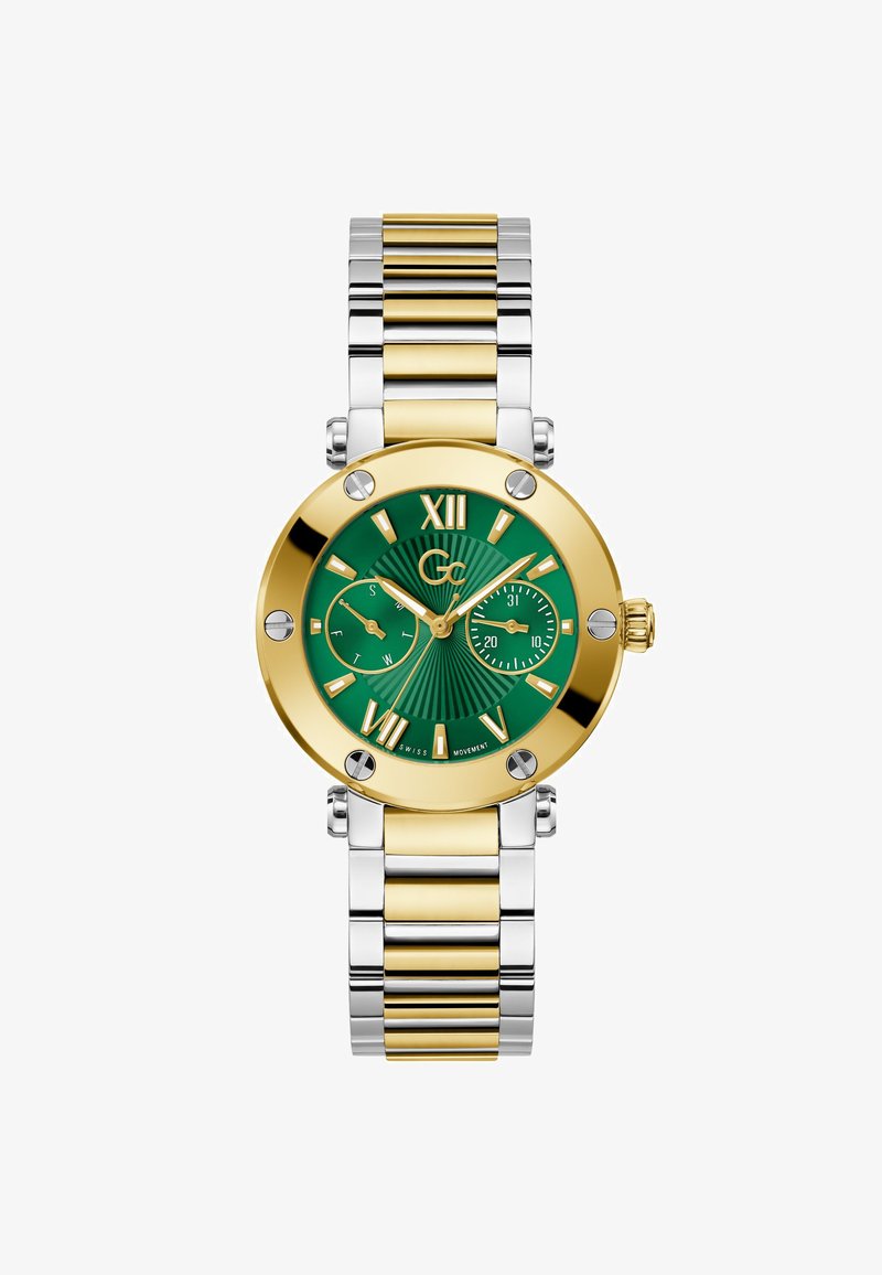 Zlata in srebrna kovinska ura z zelenim teksturiranim številčnico, velikimi rimskimi številkami, podštevilčnico in sijočimi detajli. Ima zapestno zapestnico z zankami.