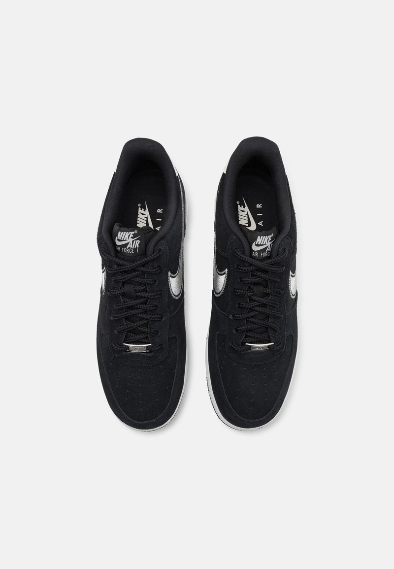 Zwarte suède sneakers met een ronde neus, witte Nike swoosh en zwarte veters. Lichte cushioning rond de enkel en geperforeerde details op de neus.