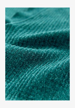 Close-up of soft teal corduroy fabric with distinct vertical ridges and subtle folds.