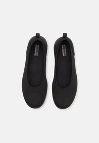 Schwarze Slipper aus perforiertem Textilobermaterial, mit abgerundeter Zehenpartie, gepolstertem Fußbett und strukturiertem Gummiaußensohle für besseren Halt.