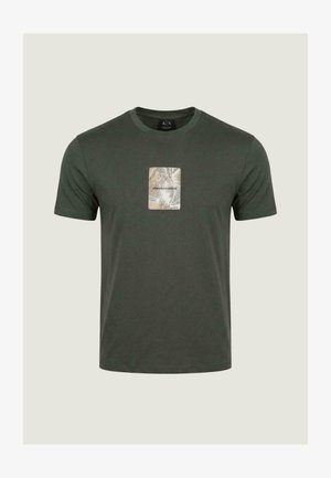 Tmavě zelené tričko s krátkými rukávy a kulatým výstřihem, na hrudi béžová obdélníková nášivka s listovými vzory a nápisem "Armani Exchange".