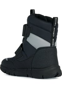 Bottes de cheville en tissu noir avec une semelle en caoutchouc texturé, ornées d'accents gris et de bandes Velcro, conçues pour le confort et le soutien.