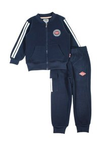 Survêtement pour enfants bleu marine avec veste zippée, bandes blanches sur les manches, poches avant, et pantalon assorti avec taille élastique et poche latérale.
