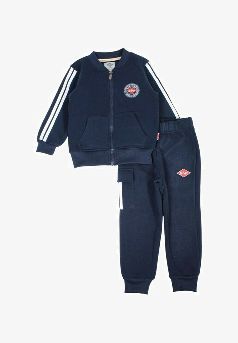 Survêtement pour enfants bleu marine avec veste zippée, bandes blanches sur les manches, poches avant, et pantalon assorti avec taille élastique et poche latérale.