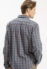 Niebiesko-czerwona koszula z długim rękawem w kratę z kołnierzykiem zapinanym na guziki. Posiada szew yoke z tyłu oraz mankiety zapinane na guziki, wykonana z miękkiego materiału.