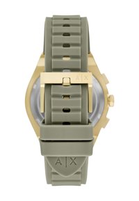 Silikonowy pasek do zegarka w stonowanej zieleni z pozłacaną klamrą grawerowaną "A|X", przymocowany do tyłu koperty zegarka w odcieniu złota z otworami do regulacji.