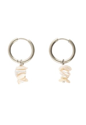 Silberne Creolen-Ohrringe mit hängenden unregelmäßigen weißen Perlen vor weißem Hintergrund.