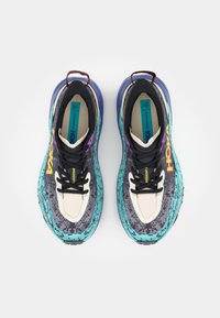 Lightweight running shoes with a black and teal pattern, cream accents, and black laces. Features a thick sole and pull tab for easy wear.