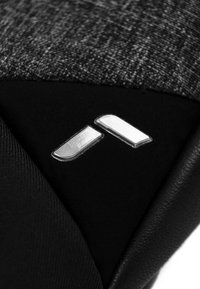 Schwarz- und grauer Stoff mit metallischen Akzenten. Glatte Oberfläche mit rechteckigen Details in Silber auf dunklem Hintergrund.