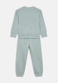Jasnoszary zestaw bluzy i spodni z miękkiej tkaniny. Posiada ściągacze na rękawach i u dołu, luźny krój dla komfortu.