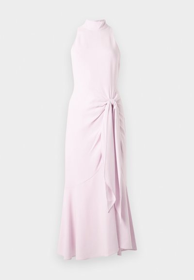 Μακριά αμάνικη φόρεμα σε ανοιχτό ροζ χρώμα με ψηλό λαιμόκοψη, πτυχώσεις στη μία πλευρά και φουντωτή άκρη, πάνω σε απλό ανοιχτό φόντο.