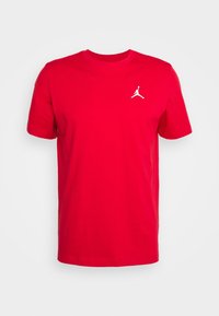 Camiseta roja de manga corta con cuello redondo, con un pequeño logo Jumpman blanco en el pecho izquierdo sobre un fondo liso.
