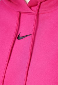 Felpa rosa con logo Swoosh nero di Nike. Realizzata in tessuto morbido con finitura testurizzata. Include cordini e tasca a marsupio.