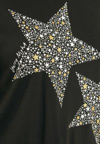 T-shirt nera con due grandi forme a stella riempite con stelle bianche, argentate e dorate di varie dimensioni, con il testo "Starry Night" in bianco.